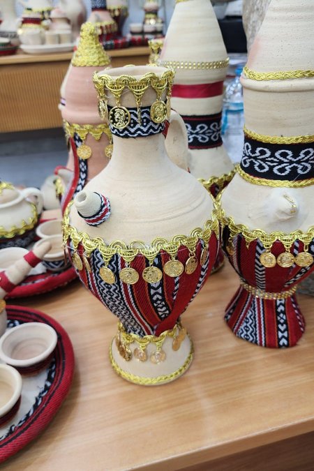 دلّة فخارية تراثية مطرّزة بخيوط حمراء وسوداء